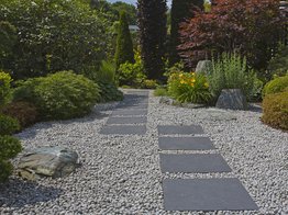 Japanischer Kiesgarten mit Trittplatten aus Naturstein und Formgehölzen